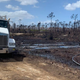 Workers clean up the oil from the ground the South Riding Point oil facility.